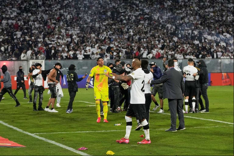 Arturo Vidal trató de calmar a los hinchas de Colo Colo que invadieron la cancha y suspendieron el partido. (Foto: AP)