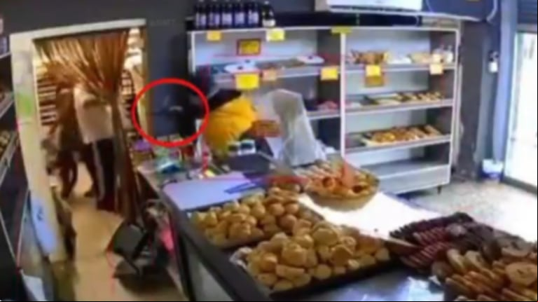 El momento en el que uno de los ladrones apuntó al empleado. (Foto: captura video Cronos Noticias)