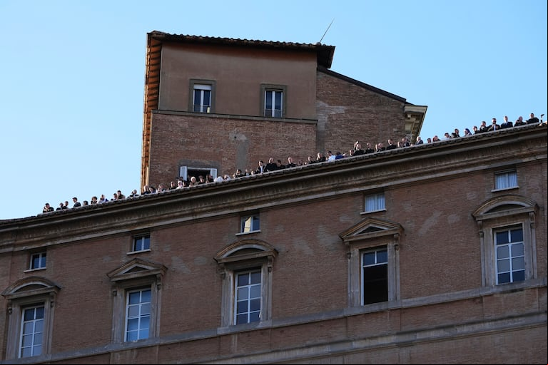 La gente observa desde una azotea junto a la Basílica de San Pedro después de que saliera humo blanco de la chimenea de la Capilla Sixtina, donde 133 cardenales se reunieron en el segundo día del cónclave para elegir al sucesor del difunto papa Francisco, en el Vaticano, el jueves 8 de mayo de 2025. (AP Foto/Alessandra Tarantino)
