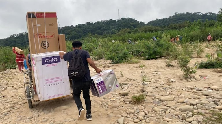 Un hombre cruza electrodomésticos por la triple frontera. (Foto: Telenoche)