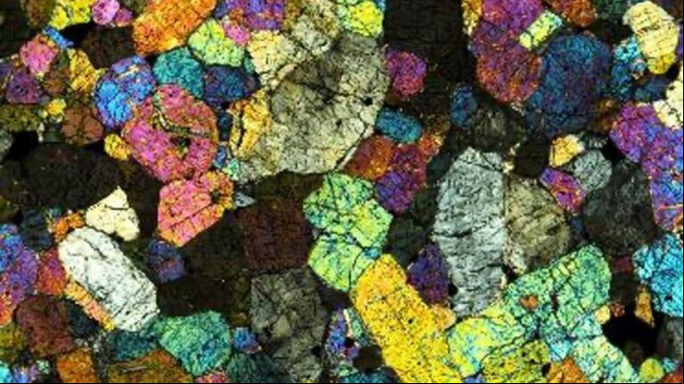 Un trozo del meteorito Chassigny que mide sólo medio milímetro de diámetro. (Foto: Instituto Scripps de Oceanografía/UC San Diego)
