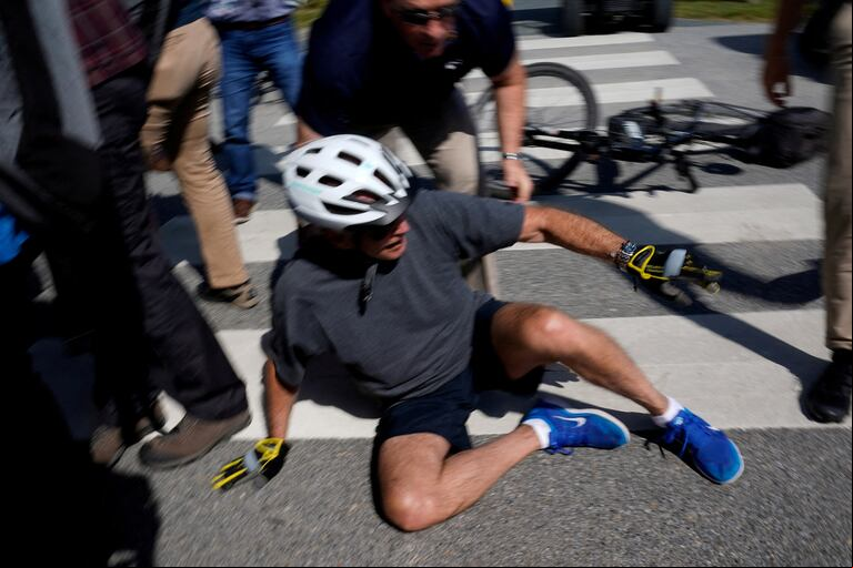 U.S. President Joe Biden falls to the ground after riding up to of the public during a bike ride in Rehoboth Beach, Delaware, U.S., June 18, 2022. REUTERS/Elizabeth Frantz TPX IMAGES OF THE DAY